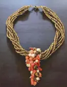  ??  ?? Statement coral necklace made of red stem coral with bronze freshwater pearls and peach pearls.