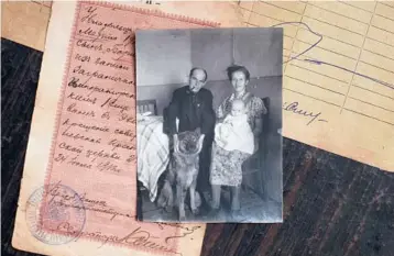  ?? EMILE DUCKE/THE NEW YORK TIMES ?? Yevgeniya Shasheva displays a photograph of herself as a child with her parents in Nizhny Odes, northern Russia. Shasheva speaks with her father’s Muscovite accent despite never having lived in the Russian capital.