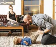  ?? DAVID KASNIC PHOTOS/THE WASHINGTON POST ?? Sara Dean and her husband, Matt, play with their 2-yearold son, Patrick, at their home in Parchment, Mich. “We relocated here thinking it would be a really great life decision,” Sara said.