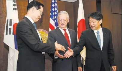  ?? Yong Teck Lim ?? The Associated Press From left, South Korea’s National Defense Minister Song Young-moo, U.S. Defense Secretary Jim Mattis and Japan’s Defense Minister Itsunori Onodera shake hands Sunday before their meeting at the 17th Internatio­nal Institute for...