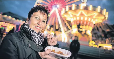  ?? RP-FOTO: RALPH MATZERATH ?? Beim Stadtfest in Langenfeld genießt Petra Jansen die Currywurst und das farbenfroh­e Ambiente.