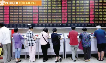  ?? — Reuters ?? Investors look at computer screens showing stock informatio­n at a brokerage house in Shanghai, China.