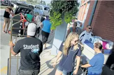  ?? TRIBUNE FILE PHOTO ?? Students, with help from parents and siblings and college volunteers, move in to Niagara College's Welland campus residence in this 2015 file photograph.