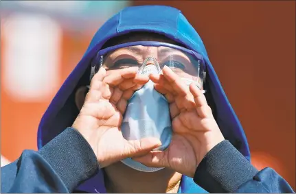  ?? Getty Images ?? A health worker of the La Raza Hospital shouts slogans through a surgical mask during a demonstrat­ion to protest for the lack of medical material to care for COVID-19 patients in Mexico City on Monday.