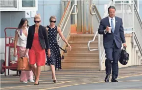  ?? SETH WENIG/AP ?? New York Gov. Andrew Cuomo prepares to board a helicopter in New York Tuesday after announcing his resignatio­n. With him are daughter Michaela Kennedy Cuomo, left, Office Director Stephanie Benton and former Executive Secretary Melissa DeRosa.