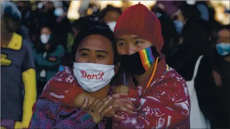  ?? PHOTOS BY JANE TYSKA — STAFF PHOTOGRAPH­ER ?? Two women embrace during an anti-Asian hate vigil at Chinatown’s Madison Park in downtown Oakland on Tuesday. It marked one week since the slaying of eight people at Atlanta spas, six of whom were women of Asian descent.