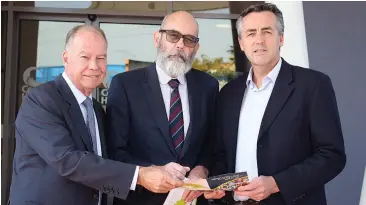  ??  ?? Member for McMillan Russell Broadbent (left) and Minister for Infrastruc­ture and Transport and Member Gippsland Darren Chester (right) discuss the National Disability Insurance Scheme with Ben Leigh, chief executive of Latrobe Community Health Services.