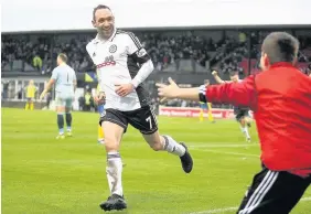  ??  ?? Joy boy Michael Moffat rushes to celebrate his goal with a youngster