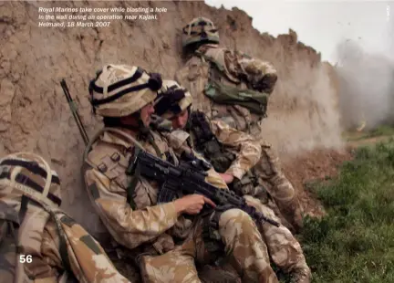  ??  ?? Royal Marines take cover while blasting a hole in the wall during an operation near Kajaki, Helmand, 18 March 2007
