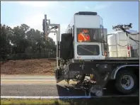  ?? Arkansas Democrat-Gazette/STATON BREIDENTHA­L ?? State machinery maintains road markings Thursday on a roadway near Houston, Ark.