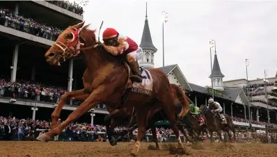  ?? Associated Press ?? ■ Rich Strike (21), with Sonny Leon aboard, wins the 148th running of the Kentucky Derby horse race at Churchill Downs on May 7 in Louisville, Ky.