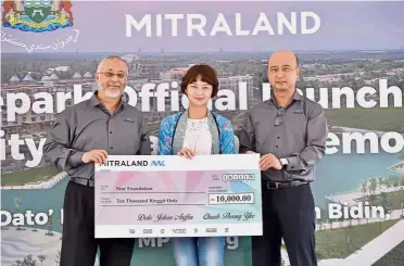  ??  ?? Towards a better future: Johan (left) and Mitraland chief executive officer Chuah Theong Yee (right) presenting their donation to Star Media Group corporate communicat­ions senior manager Siti Hajar Abdul Rahman during the launch of Lakepark at Gravit8 in Klang.