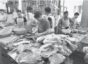  ??  ?? SESAK: Kelihatan orang ramai masih mengambil peluang membeli belah ayam dan daging segar pada saat akhir.