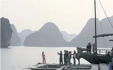  ??  ?? ABOVE
Chinese tourists take pictures on a floating raft in Ha Long Bay in northern Vietnam.