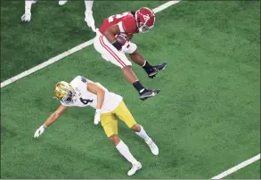  ?? Carmen Mandato / Getty Images ?? Alabama running back Najee Harris leaps Notre Dame cornerback Nick McCloud during the first quarter of the College Football Playoff semifinals at the Rose Bowl on Friday. Alabama won 31-14.