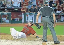  ??  ?? The Diamondbac­ks' Paul Goldschmid­t scores on Daniel Descalso’s game-winning hit against the Phillies in the 11th inning on Sunday.