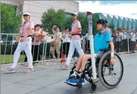  ?? YUE YUEWEI / XINHUA ?? Feng Yazhu, a disabled swimmer, carries the torch toward its destinatio­n at the 13th National Games in Tianjin, Aug 27-Sept 8. Hers was the 33rd leg of the torch relay.