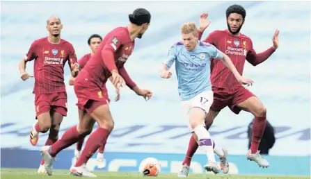  ??  ?? Manchester City’s Kevin De Bruyne is surrounded by Liverpool players at the Etihad Stadium on Thursday night. City beat League winners Liverpool 4-0. | Reuters