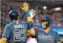  ?? AP PHOTO BY ALEX BRANDON ?? The Atlanta Braves’ Adam Duvall celebrates Wednesday with Tyler Flowers after Flowers’ two-run home run during the fourth inning of their game against the Washington Nationals at Nationals Park.