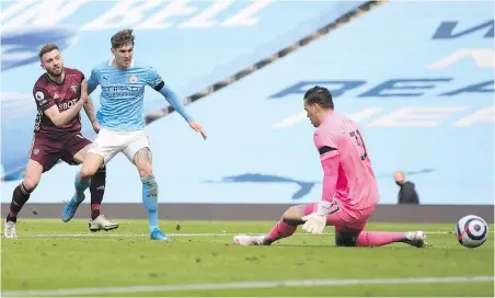  ?? AP VIA POOL ?? Leeds United’s Stuart Dallas, left, shoots past Manchester City defender John Stones and goalkeeper Ederson to score his team’s second goal at Etihad Stadium on Saturday.