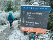  ?? HAVEN DALEY/AP ?? A hiker walks along a snow-covered trail Friday at Mount Tamalpais State Park in Mill Valley, Calif.