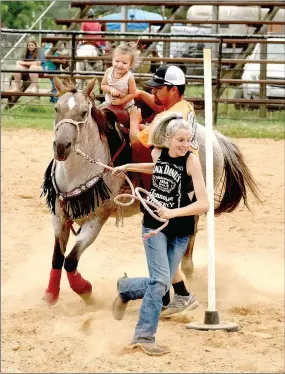  ?? MARK HUMPHREY ENTERPRISE-LEADER ?? Lincoln Riding Club 2019 Rodeo Queen Landree Cunningham demonstrat­es a servant’s heart while taking Taylin Scraper through the pole bending course at the June 28 Lincoln Riding Club Play Day. Taylin thoroughly enjoyed running the poles with her daddy, Jalen Scraper, holding her on the horse. Toddlers are allowed to compete in the lead line category. The next Play Day is scheduled for July 12.