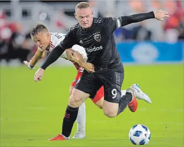  ?? CANADIAN PRESS FILE PHOTO ?? D.C. United forward Wayne Rooney (9) fights off New England Revolution defender Antonio Delamea Mlinar, left, to maintain control of the ball during an MLS match Aug. 19 in Washington,D.C. Eliminated from playoff contention,Toronto FC has been reduced to the rank of spoiler for the final three games of the MLS regular season. And, as luck would have it, TFC faces two teams jockeying for the final post-season berth in the Eastern Conference, starting Wednesday with a game against Rooney and D.C. United.