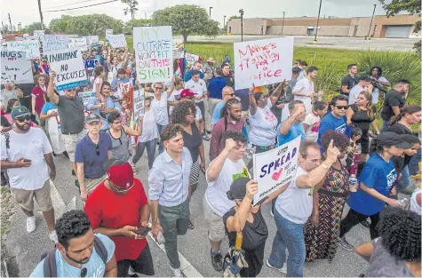  ??  ?? Demonstrat­ors hold signs during the ‘Keep Families Together’ rally outside the Homestead temporary shelter for unaccompan­ied migrant children in Homestead, Florida on Saturday.