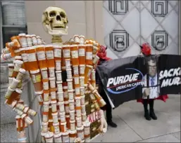  ?? Carolyn Kaster/Associated Press ?? “Pill Mann” made by Frank Huntley of Worcester, Ma., from his opioid prescripti­on pill bottles, during a protest by advocates for opioid victims outside the Department of Justic in Dec. 2021.