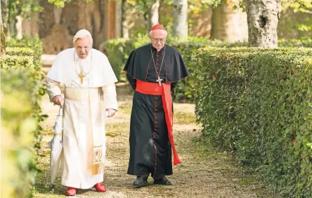  ??  ?? Anthony Hopkins and Jonathan Pryce in “The Two Popes,” a Netflix film that reveals the schism in the church. Pope Francis greeted Pope Benedict XVI, far right, at the Vatican in 2017.