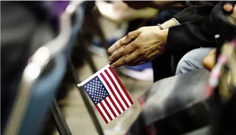  ?? (AP Photo/Jae C. Hong) ?? Rupinder Garha, an immigrant from India, holds a small U.S. flag during a naturaliza­tion ceremony at the Los Angeles Convention Center, Wednesday, Feb. 15, 2017, in Los Angeles. Thousands of people, some wiping tears from their eyes, became United...