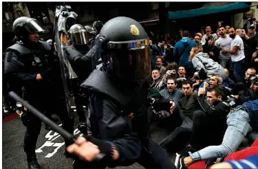  ?? AP/MANU FERNANDEZ ?? Spanish National Police try to dislodge pro-referendum supporters sitting down on a street Sunday in Barcelona, Spain. Catalonia’s planned referendum on secession was held Sunday by the pro-independen­ce Catalan government but Spain’s government called...