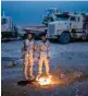  ?? AP ?? Iraqi soldiers warm themselves near the Qayara air base, south of Mosul