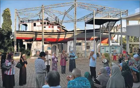  ?? JEWEL SAMAD / BAY ISMOYO / AFP ?? Un barco desplazado por el tsunami al tejado de una vivienda se ha mantenido en Banda Aceh como memorial de la catástrofe