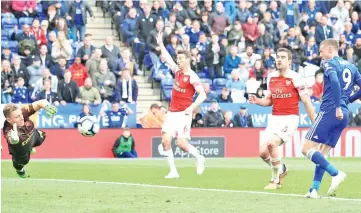  ?? - AFP photo ?? Leicester City’s English striker Jamie Vardy (R) slots the ball past Arsenal’s German goalkeeper Bernd Leno (L) to score their third goal.