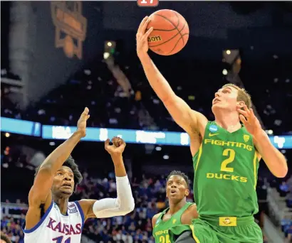  ?? DENNY MEDLEY/USA TODAY SPORTS ?? Oregon guard Casey Benson (2) goes up for a shot as Kansas guard Josh Jackson (11) defends during the first half in the NCAA Tournament Midwest Regional final at Sprint Center on Saturday in Kansas City, Mo. The Ducks defeated the top-seeded Jayhawks...