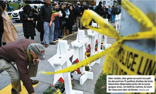  ??  ?? Hier matin, des gens se sont recueillis devant les 11 petites étoiles de bois blanches disposées près de la synagogue avec, en lettres noires, le nom de chacune des victimes. PHOTO AFP