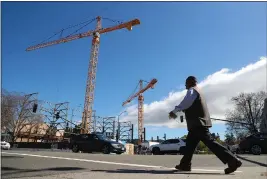  ?? ARIC CRABB — BAY AREA NEWS GROUP ?? A pedestrian walks past a housing and retail space constructi­on project at 51st Street and Telegraph Avenue on March 12, 2019, in Oakland.