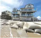  ?? AP PHOTO/CHUCK BURTON ?? Sand bags surround homes on North Topsail Beach, N.C., Wednesday as Hurricane Florence threatens the coast.