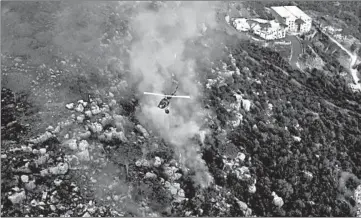  ?? AP ?? WIldfires in Mideast: In this frame grab from video, an army helicopter drops water on a forest fire in Ras el-Harf village, in the Baabda district of Lebanon on Friday. Wildfires around the Middle East triggered by a heatwave have killed two people, forced thousands to leave their homes and detonated landmines along the Lebanon-Israel border, officials said.