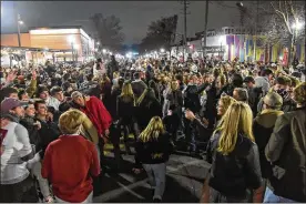  ?? BENJAMIN FLANAGAN / ASSOCIATED PRESS ?? Alabama fans celebrate in the street in Tuscaloosa on Monday night after the Crimson Tide’s 52-24 victory againstOhi­o State in college football’s national championsh­ip game in Miami. Many fans ignored basic precaution­s against the coronaviru­s such as wearing facemasks.