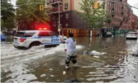  ?? Photograph: Jake Offenhartz/AP ?? A man works to clear a drain in floodwater­s in Brooklyn, New York, on 29 September.