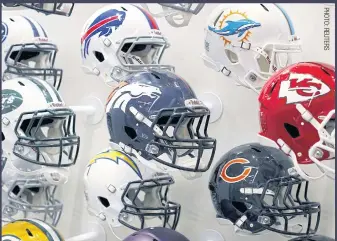  ??  ?? Team helmets are displayed at the NFL headquarte­rs in New York.