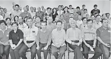  ??  ?? Dr Sim (seated fourth right) and Tan (third left) with representa­tives of the 30 recipients. — Photo by Chin Tze Pin