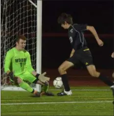  ?? PETE BANNAN – DIGITAL FIRST MEDIA ?? Strath Haven’s Nick Palermo goes in on Archbishop Wood goalie Connor Ford for the game-tying goal Tuesday night at West Chester East. The Panthers would go on to a 3-2 victory in the PIAA Class 3A semifinal game.