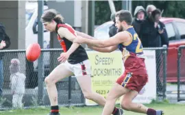  ??  ?? Nilma-Dranum’s Riley Sculz attempts to keep the ball in play while Warragul Industrial­s opponent Darren Blaney gives chase.