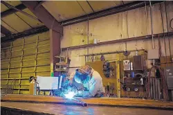  ?? COURTESY OF AMFABSTEEL ?? An Amfabsteel employee works on a piece of steel at the company’s Bernalillo plant. The steel fabricatio­n and manufactur­ing firm is planning to more than double the size of its plant.