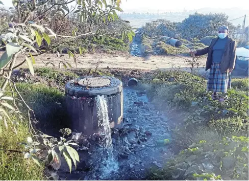  ?? Picture: SIKHO NTSHOBANE ?? HEALTH RISK: Waterfall Park resident Rose Mzazela pointing to a blocked sewer manhole that has been spewing raw sewage onto the surfaces next to their homes for months. Some residents have even fled their homes as a result.