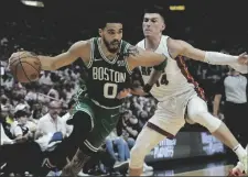  ?? AP PHOTO/LYNNE SLADKY ?? Boston Celtics forward Jayson Tatum (0) dribbles the ball as Miami Heat guard Tyler Herro (14) defends during the first half of Game 2 of the NBA basketball Eastern Conference finals playoff series, on Thursday in Miami.