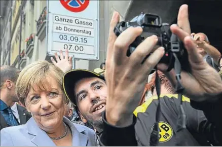  ?? FABRICE COFFRINI / AFP ?? Angela Merkel accedió a hacerse una selfie con un transeúnte en las calles de Berna (Suiza) el jueves